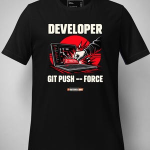 May include: A black short-sleeve t-shirt featuring a graphic of a fist hitting a laptop keyboard. The text reads DEVELOPER and GIT PUSH -- FORCE. The design includes a red circular background element and a button labeled FORCE PUSH on the screen.