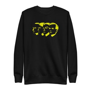 Op de afbeelding: Zwart sweatshirt met een geel silhouet van vier gezichten.