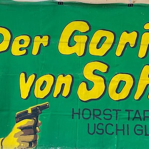 Pode incluir: Um cartaz de filme vintage com o texto "Der Gorilla von Soho" em amarelo sobre um fundo verde. O cartaz apresenta uma ilustração em tons de amarelo de um homem segurando uma arma. O texto "HORST TAPPERT USCHI GLAS" também é visível.