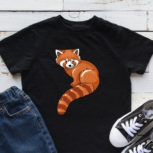 May include: Black t-shirt with a red panda graphic. The panda is sitting on its haunches with its tail curled around its body. The panda is looking to the left.