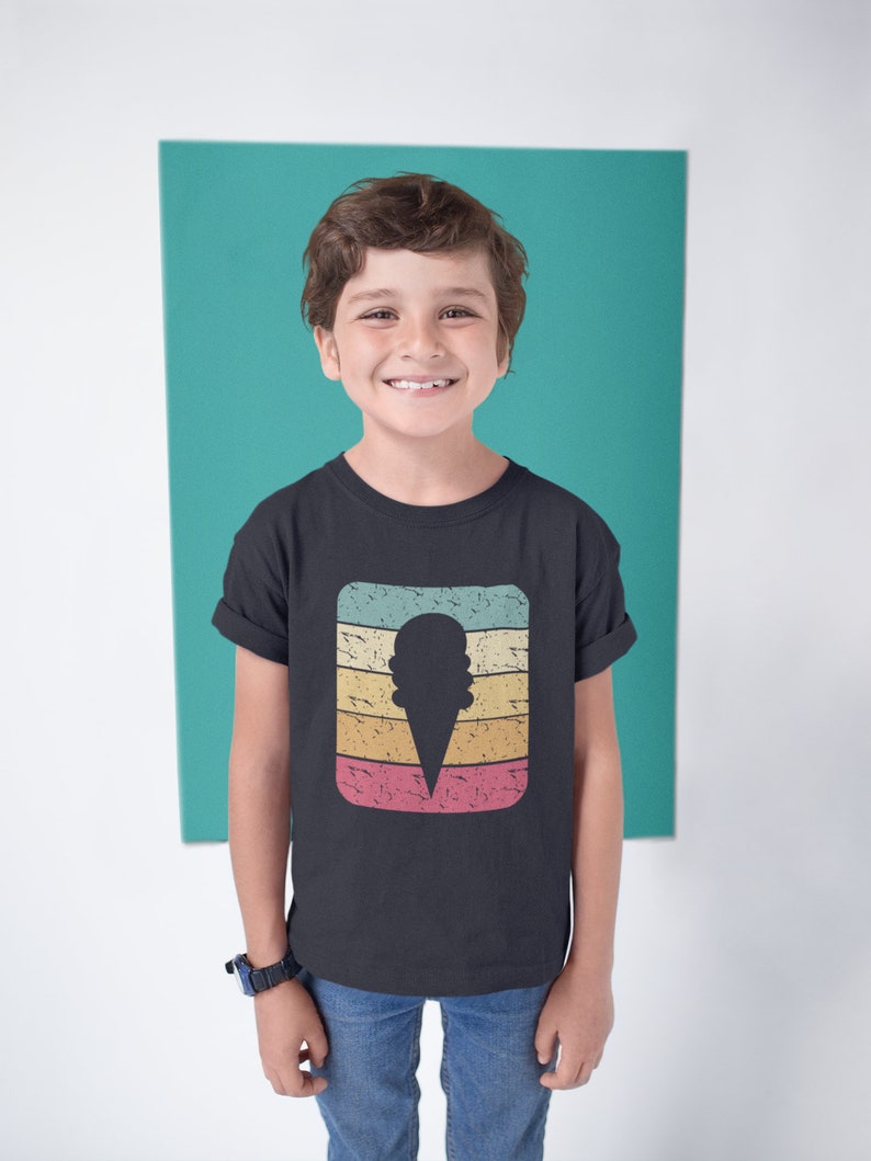 May include: A young person wearing a black t-shirt with a vintage-style ice cream cone graphic. The graphic features a silhouette of an ice cream cone with a multi-colored striped background.