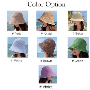 May include: A selection of woven sun hats in various colors, including pink, khaki, beige, white, brown, green, and violet. The hats have a classic bucket hat shape with a slightly downward-sloping brim. The text "Color Option" is at the top.