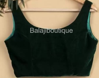 Pode incluir: Uma blusa sem mangas de veludo verde escuro com decote redondo. A blusa está em um cabide e tem o texto "Balajiboutique" impresso na frente.