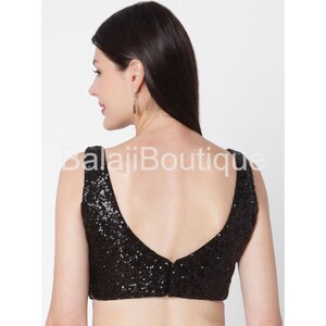 May include: Black sequined sleeveless blouse with a deep V-neck back.