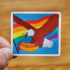 Águia segurando um cachorro-quente com adesivo de bandeira gay - Adesivo à prova d'água, adesivo LGBTQ+ Queer, presente, adesivo para laptop, adesivo para garrafa de água