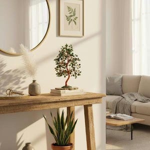 May include: A wooden console table with a decorative tree sculpture, a framed botanical print, and a potted snake plant. A round gold mirror hangs on the wall above the table. The room has a neutral color palette.