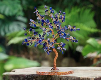 May include: A handcrafted tree sculpture with a copper wire trunk and branches, adorned with vibrant blue gemstone chips. The tree sits on a round, decorative base, creating a unique and artistic home decor piece.