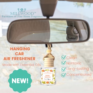 May include: A hanging car air freshener with a wooden cap and a glass bottle. The bottle is labeled "Mango Smoothie Car Diffuser" and is made with essential oils. The air freshener is advertised as clean, nontoxic, long-lasting, and concentrated. The text "NEW!" is also visible in the image.