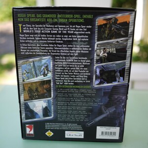 Puede incluir: La parte trasera de una caja de videojuego para "Rogue Spear: Urban Operations" presenta capturas de pantalla del juego y texto en varios idiomas. La caja es principalmente negra con texto verde y blanco, y el logotipo de Ubi Soft es visible.