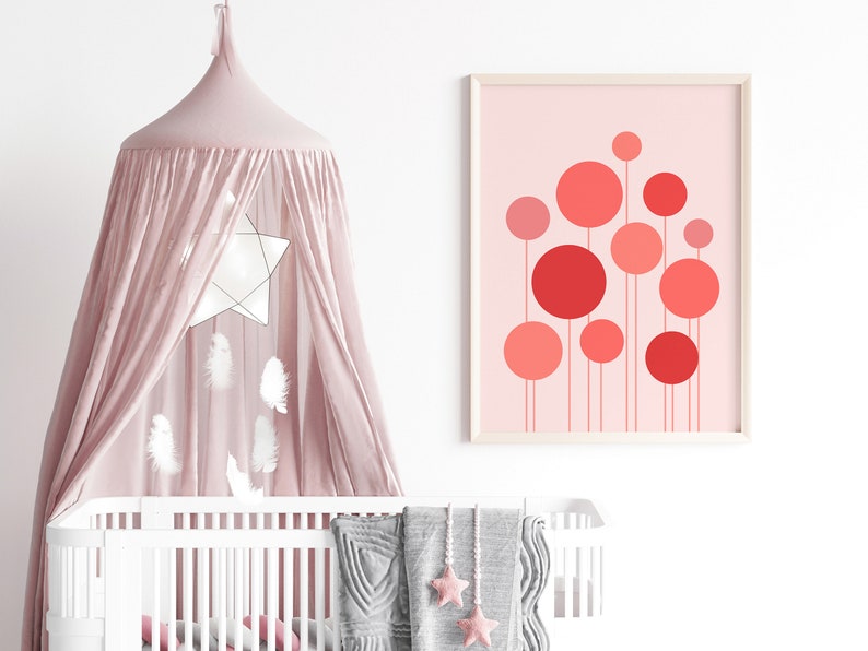 May include: A pink and white nursery with a white crib, a pink canopy, and a framed print of red and pink circles on a pink background.
