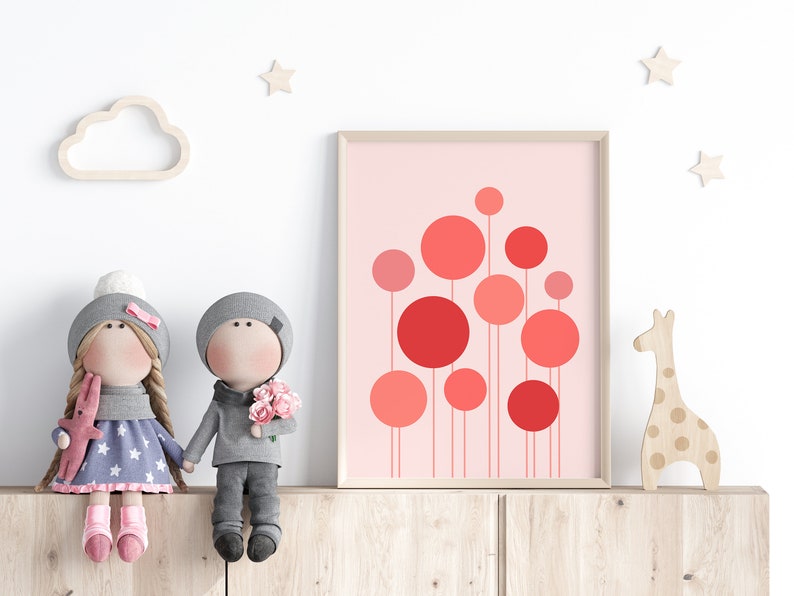 May include: A framed print with a pink background and red circles of varying sizes. The print is hanging on a wall above a wooden shelf with two dolls and a giraffe figurine.