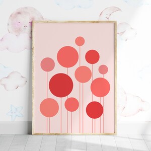 May include: A framed print with a pink background and a design of red and pink circles on stems. The circles are arranged in a cluster, with the largest circle at the top.
