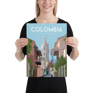 May include: A colorful illustration of a street scene in Cartagena, Colombia. The image features a narrow street lined with colorful buildings, with a tall church in the background. The text "COLOMBIA CARTAGENA" is displayed at the top of the image.