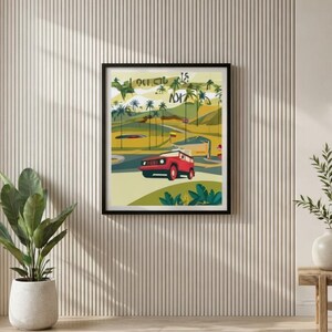 May include: A framed art print featuring a red SUV driving on a road with palm trees and a yellow bus. The artwork has a retro travel theme with the text "15" and other text. The print is displayed on a textured white wall.