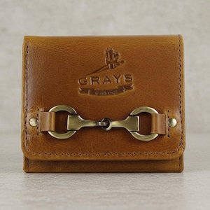 May include: A tan leather wallet with a brass-coloured clasp. The wallet features the embossed word "GRAYS". The rectangular wallet has a stitched border and is a classic design.