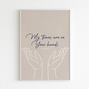Puede incluir: Una impresión de pared beige imprimible con un contorno blanco de dos manos levantadas. El texto "My times are in Your hands." está impreso en azul oscuro con el texto "PSALM 31:15" impreso en azul oscuro más pequeño debajo.