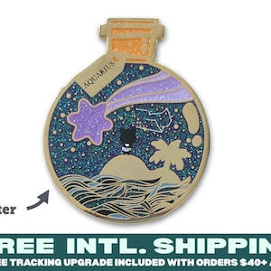 Pode incluir: Pin de esmalte dourado em forma de garrafa com um design de glitter roxo e azul no interior. A garrafa tem uma rolha de cortiça e a palavra "AQUARIUS" está escrita no lado. O design dentro da garrafa apresenta uma estrela, uma estrela cadente, uma constelação, uma palmeira e uma pequena figura preta em pé em uma pequena ilha.