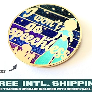 Puede incluir: Un pin redondo de color dorado con un fondo brillante y una silueta de princesa. El texto "I won't go speechless" está escrito en letras doradas.