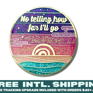 May include: A gold-toned enamel pin with a glittery sunset design. The pin features a rainbow arch over a beach scene with waves and the text "No telling how far I'll go".