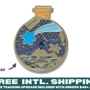 May include: Gold-tone enamel pin shaped like a bottle with a cork stopper. The bottle contains a blue star, a black cat, a palm tree, and a constellation on a dark blue background with glitter. The text "SAGITTARIUS" is on the bottle label.