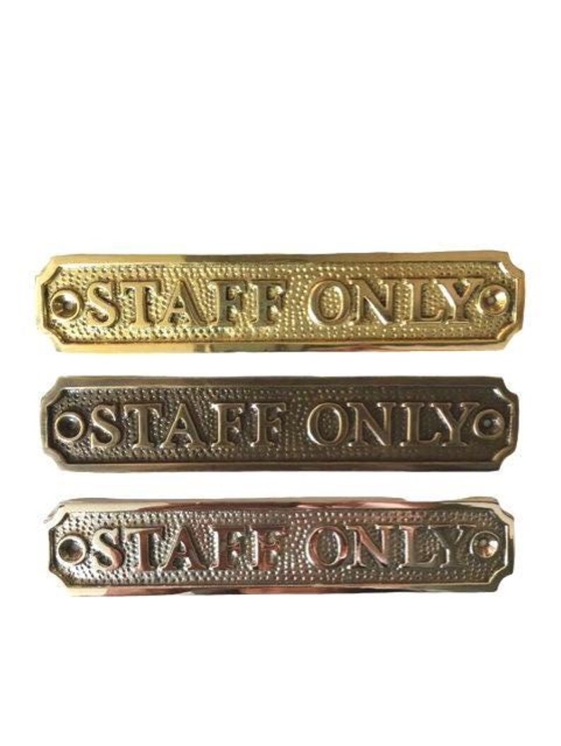 May include: Three rectangular metal signs with a textured background and the embossed text STAFF ONLY. The top sign is polished gold, the middle is dark bronze, and the bottom is a copper-toned metal. Each sign has two screw holes for mounting.