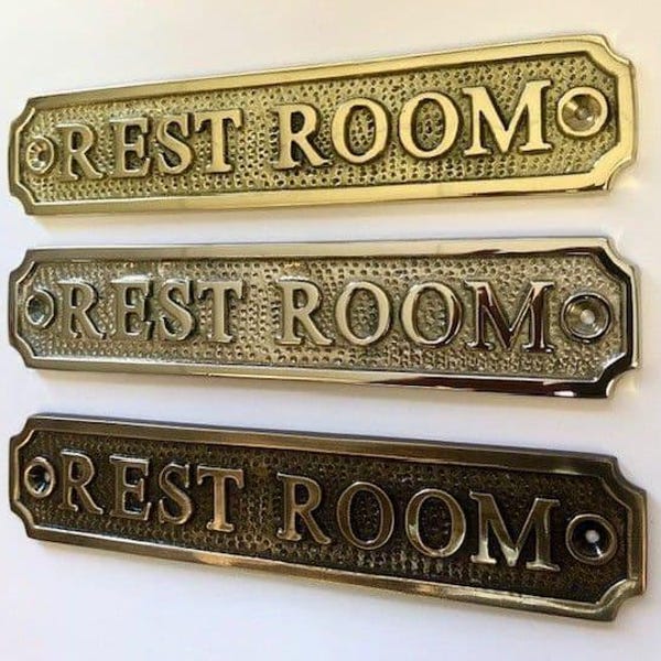 Rest room door sign available in three finishes - nickel, antique bronze or brass. Matching screws are included. 16.7 cm X 3.4 X 0.4 cm