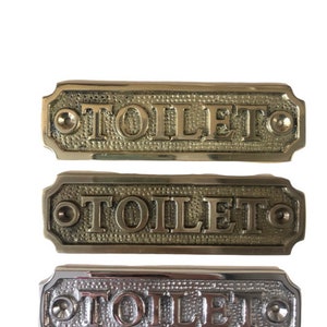Toilet door sign available in three finishes - nickel, antique bronze or brass. Matching screws are included. 11.4 cm X 3.2 x 0.4 cm.