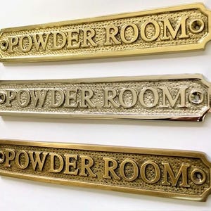Powder room door sign made from solid brass choose finish. Brass, nickel or antique bronze. The plaque is sent with screws.20x3.2x0.4 CM