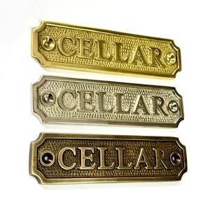 Cellar door sign available in three finishes - nickel, antique bronze or brass. Matching screws are included. 12.5 cm X 3 cm.