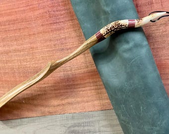 May include: A wooden shoe horn with a curved handle and a decorative antler tip with red and white accents.