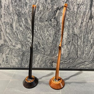 Edle handgearbeitete Schuhanzieher aus Eschenholz, präsentiert auf edlen Ständern.