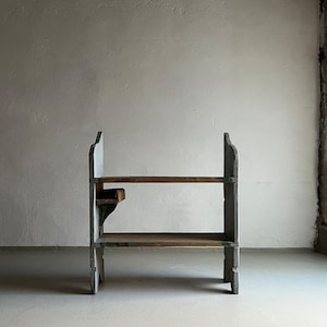 May include: A rustic wooden shelf unit with two shelves and a small side shelf. The shelf is painted white with green accents and has a distressed look.