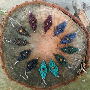 May include: A set of 10 pairs of earrings with tiger's eye stones. The earrings are made with macrame and come in a variety of colors, including brown, blue, black, and green.