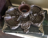 Vintage cast iron candlestick, black in colour, with beautiful volute patterns.