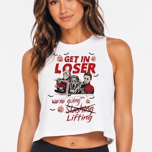 May include: A white sleeveless crop top featuring a graphic print of three horror movie characters in a car. The text reads "GET IN LOSER" above the characters and "We're going Slashing Lifting" below, with the word "Slashing" crossed out in red.