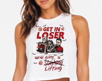 May include: A white sleeveless crop top featuring a graphic print of three horror movie characters in a car. The text reads "GET IN LOSER" above the characters and "We're going Slashing Lifting" below, with the word "Slashing" crossed out in red.