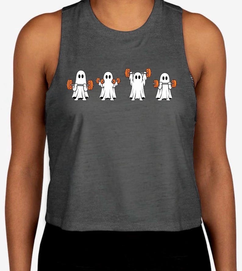 May include: A dark gray sleeveless crop top featuring a graphic print of four white ghosts in a row, each lifting orange dumbbells in different positions. The ghosts have simple black oval eyes and are depicted performing various weightlifting exercises.