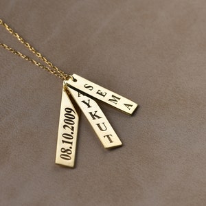 May include: Gold necklace with three rectangular pendants. The pendants are engraved with the names "SEMA", "AYKUT", and the date "08.10.2009".