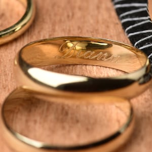May include: Two gold wedding bands, one with the name "Diana" engraved on the inside.