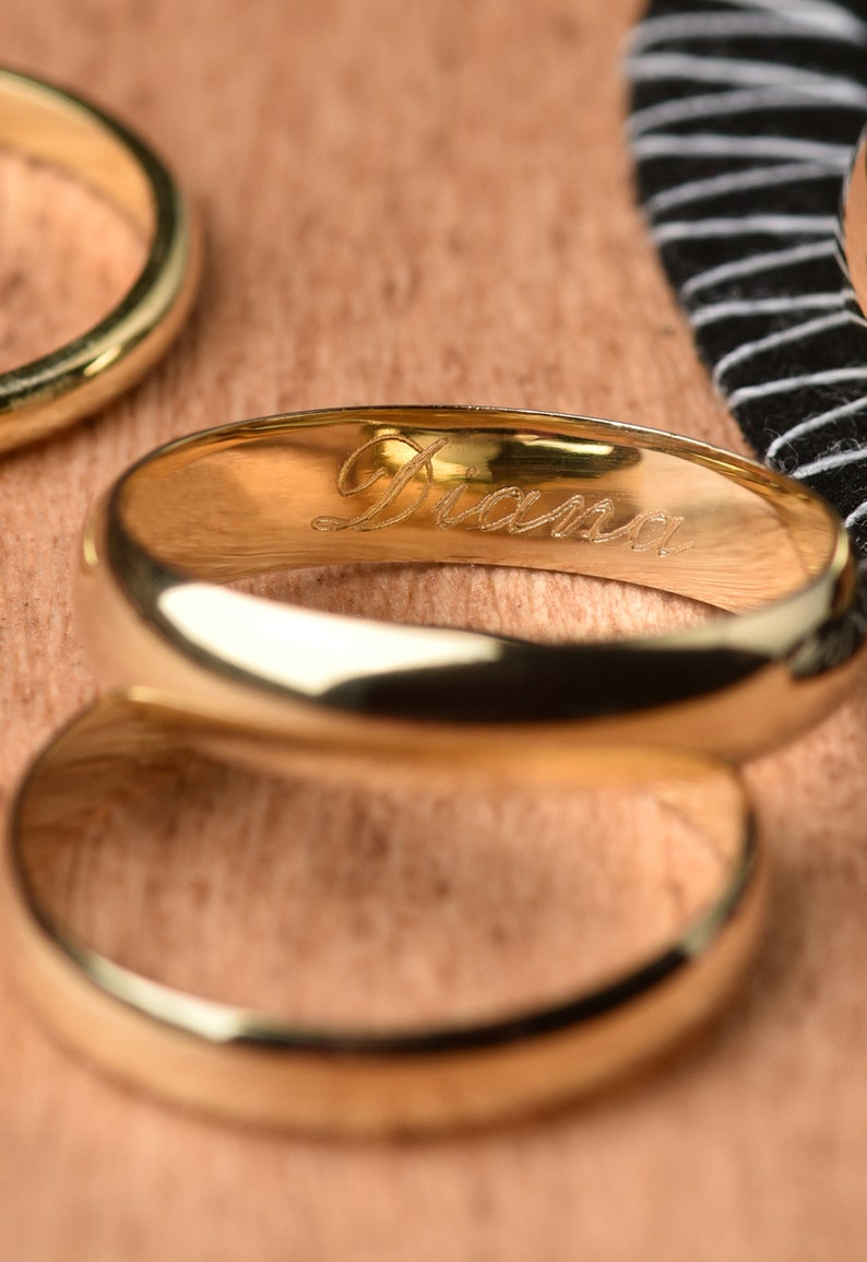 May include: Two gold wedding bands, one with the name "Diana" engraved on the inside.