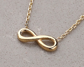 May include: A gold infinity symbol necklace with a delicate chain.
