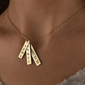 May include: Gold necklace with four rectangular pendants. The pendants are engraved with the names "SEMA", "YUKUT", and the date "2002.01.08".