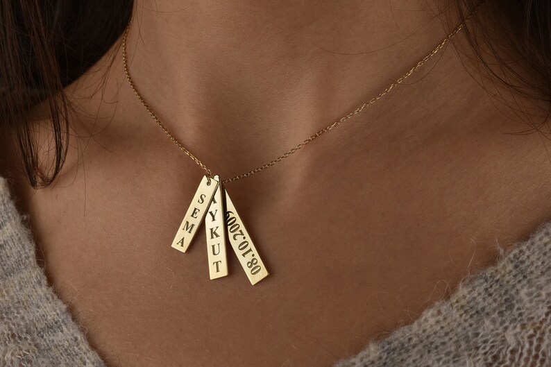 May include: Gold necklace with four rectangular pendants. The pendants are engraved with the names "SEMA", "YUKUT", and the date "2002.01.08".