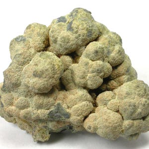 May include: A close-up of a mineral specimen with a textured, bumpy surface. The rock formation is primarily light green and tan, with darker gray patches. The overall shape is irregular and organic, suggesting a natural, unpolished state.