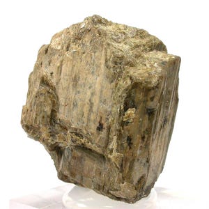 Pode incluir: Um espécime mineral bruto e não polido com uma estrutura cristalina em bloco. A pedra apresenta uma paleta de cores variadas em tons terrosos de verde-oliva, bege e cinza acastanhado, com uma superfície rugosa e estrias verticais visíveis.