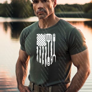 May include: A green t-shirt with a white distressed American flag design featuring a spatula, knife, and fork.