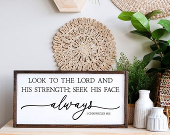 May include: A white wooden sign with a brown frame, featuring the text "LOOK TO THE LORD AND HIS STRENGTH; SEEK HIS FACE always 1 CHRONICLES 16:11".