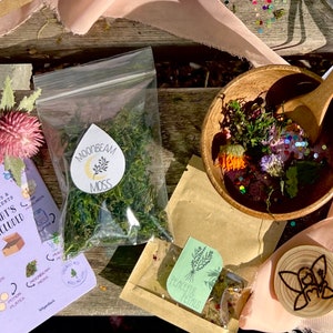 May include: A craft kit with a variety of items, including dried moss, flower petals, glitter, and wooden decorations. The kit also includes a booklet with instructions and a list of supplies. The text on the booklet reads "Supplies & Ingredients What's Included".