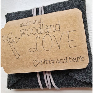 May include: A small gray felt pouch with a brown paper tag that says "made with woodland love bitty and bark".