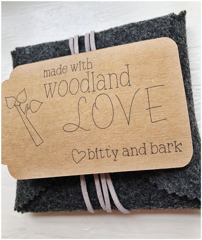 May include: A small gray felt pouch with a brown paper tag that says "made with woodland love bitty and bark".